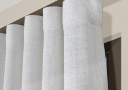 Tenda a onda bianca con pieghe regolari montata su binario moderno